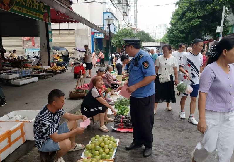 图为城管执法人员在开展早市宣传活动,倡导文明有序经营.jpg